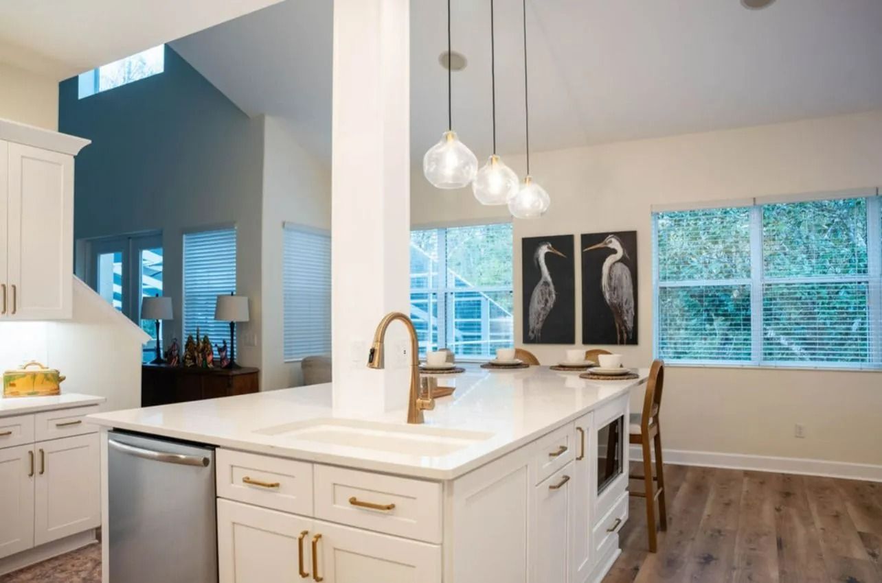 A kitchen with white cabinets and a large island in the middle.