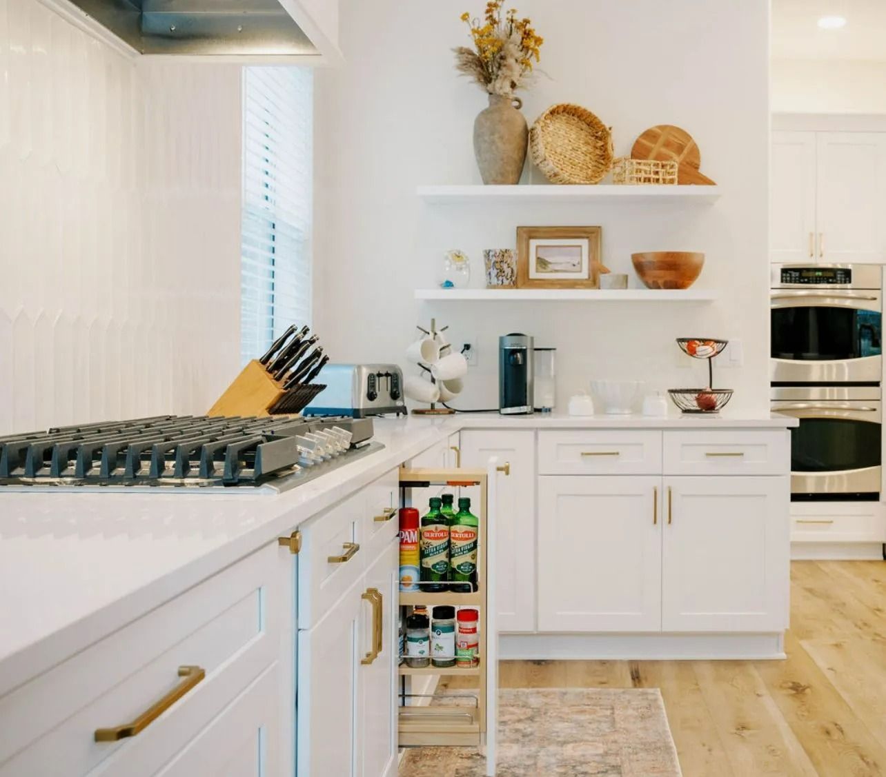 A kitchen with white cabinets and stainless steel appliances