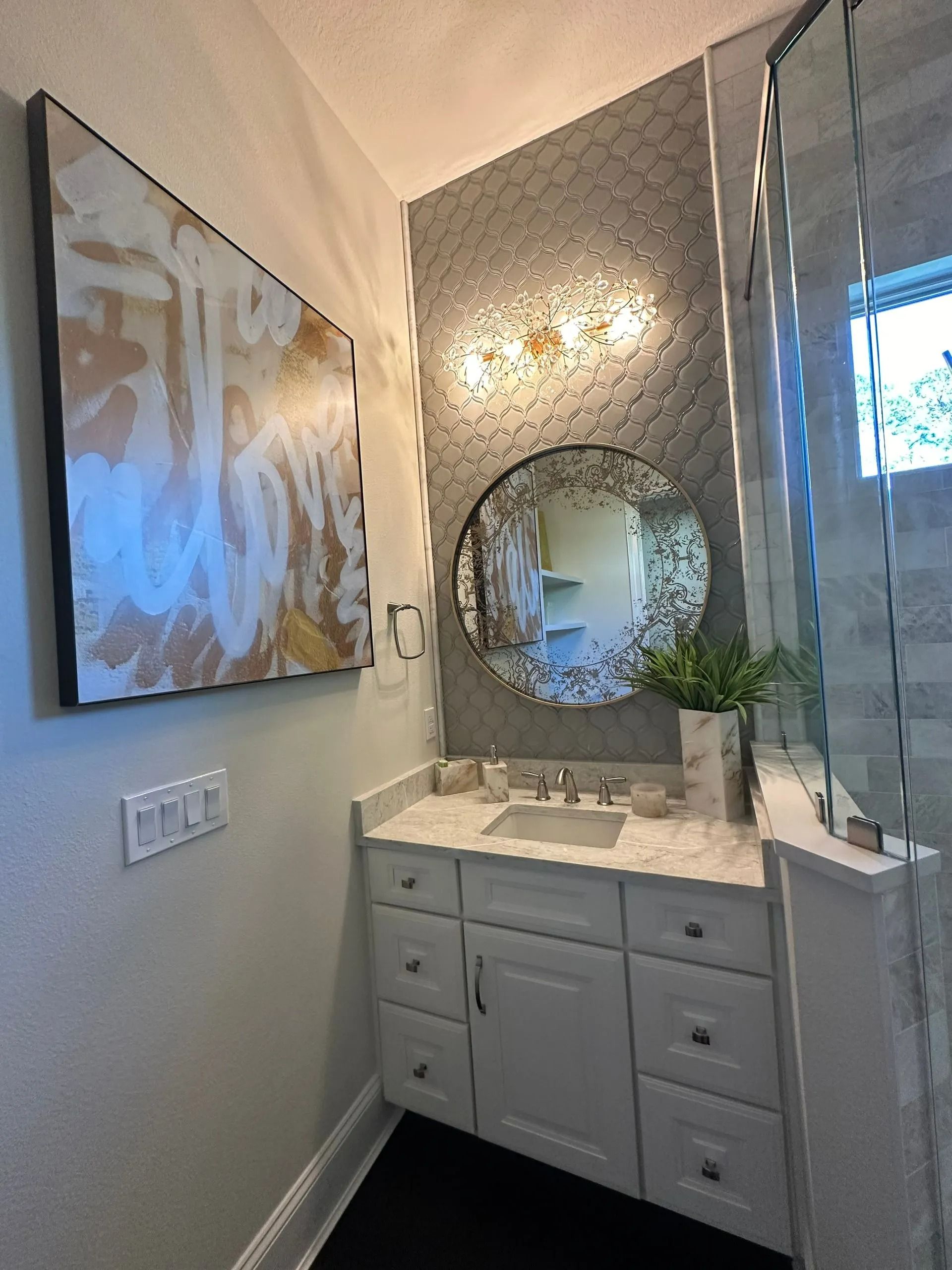 A bathroom with a sink , mirror and painting on the wall.