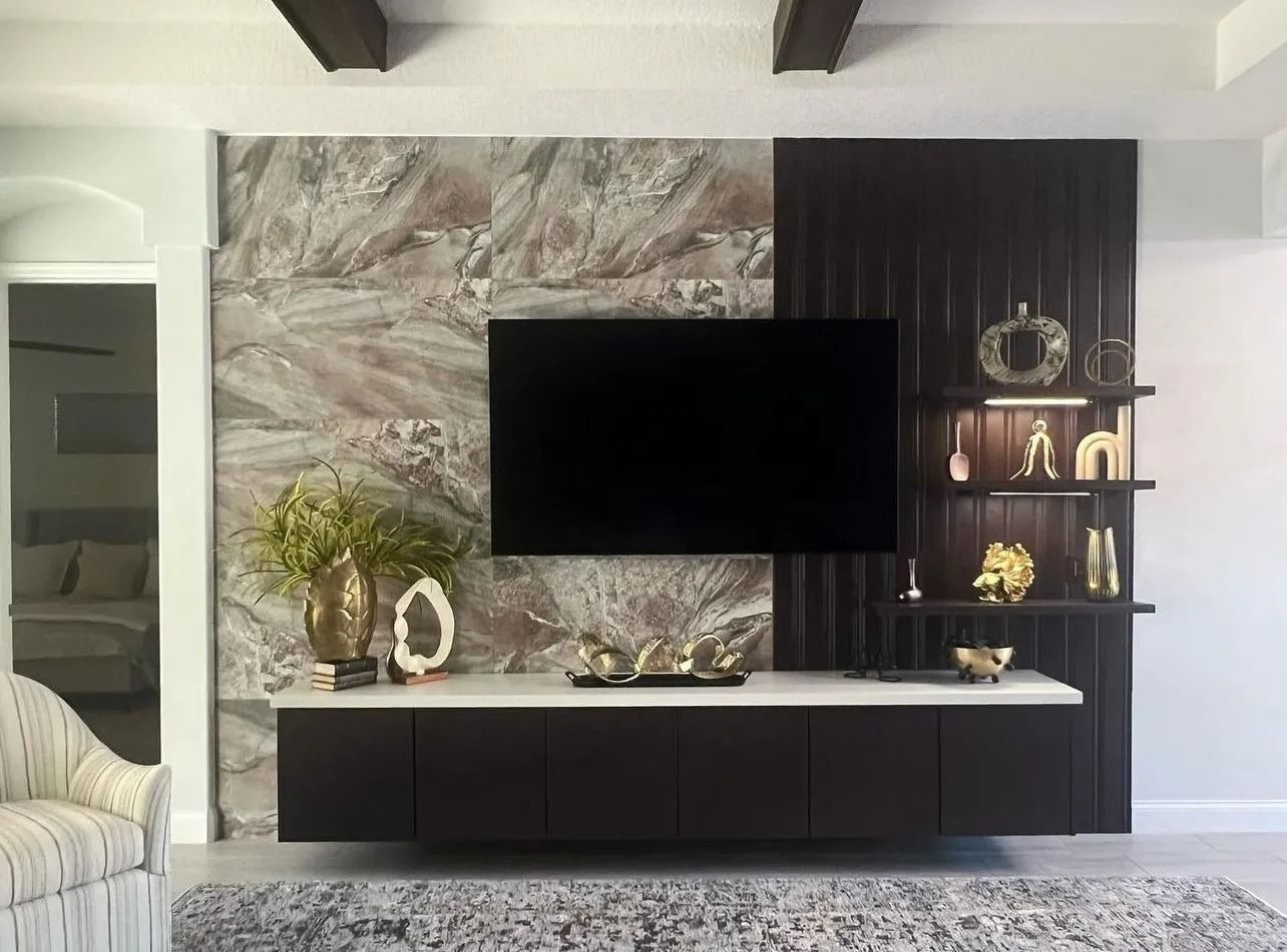 A living room with a flat screen tv mounted on the wall.