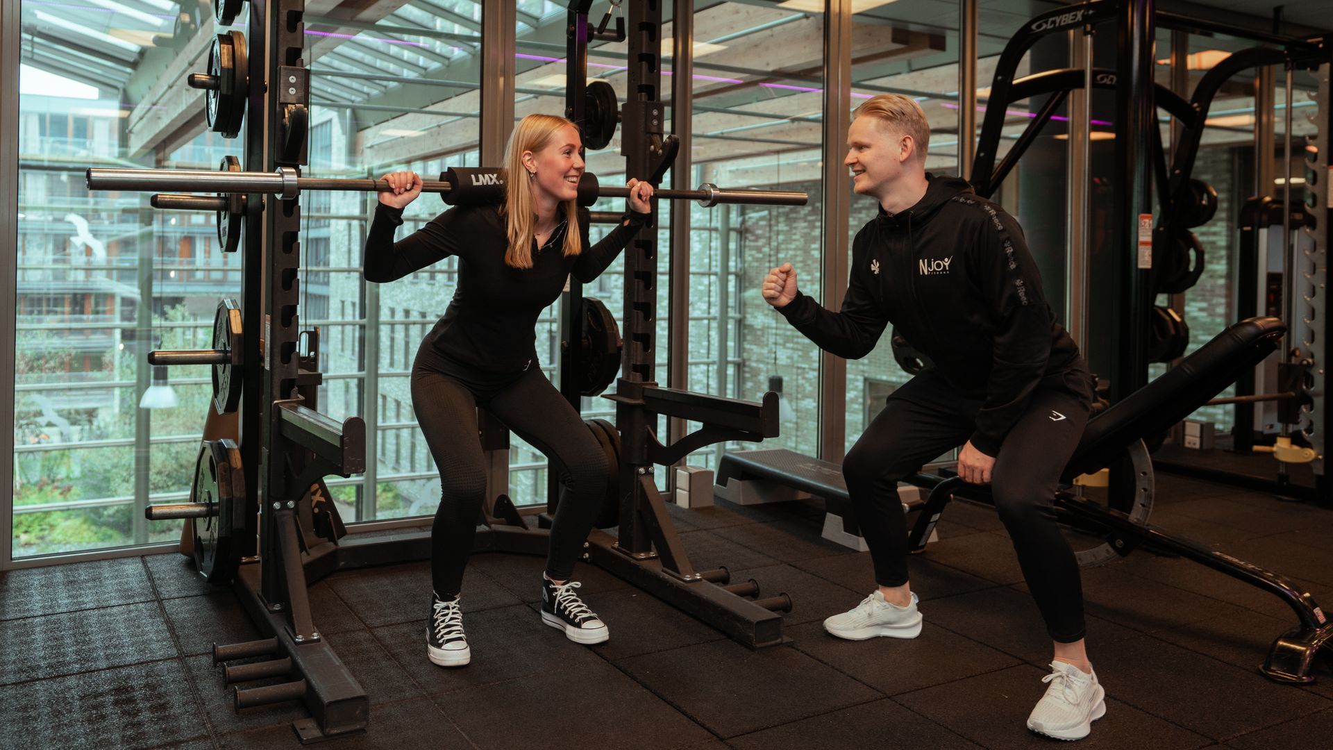Een sportschool vol met fitnessapparatuur en televisies.