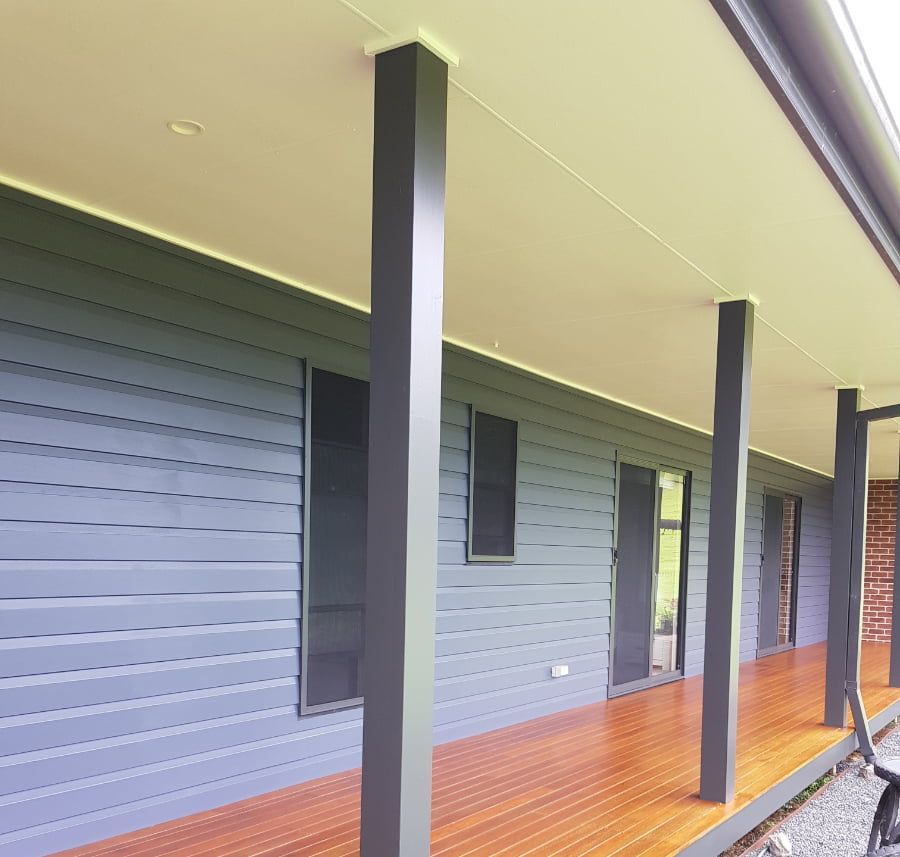 A blue house with a wooden porch and columns — Axis Painting in Coffs Harbour, NSW