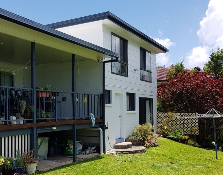 A large white house with a balcony and a large lawn in front of it — Axis Painting in Coffs Harbour, NSW