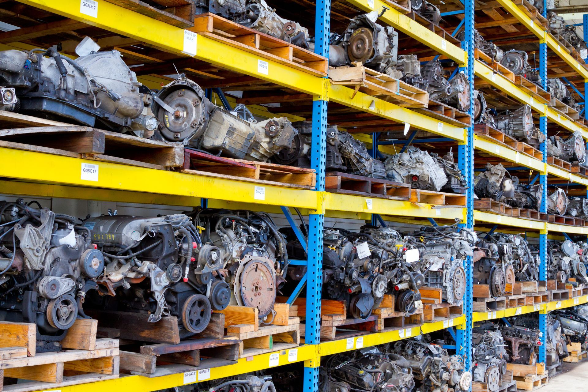 View of different junk auto parts recyclers in yellow shelves.