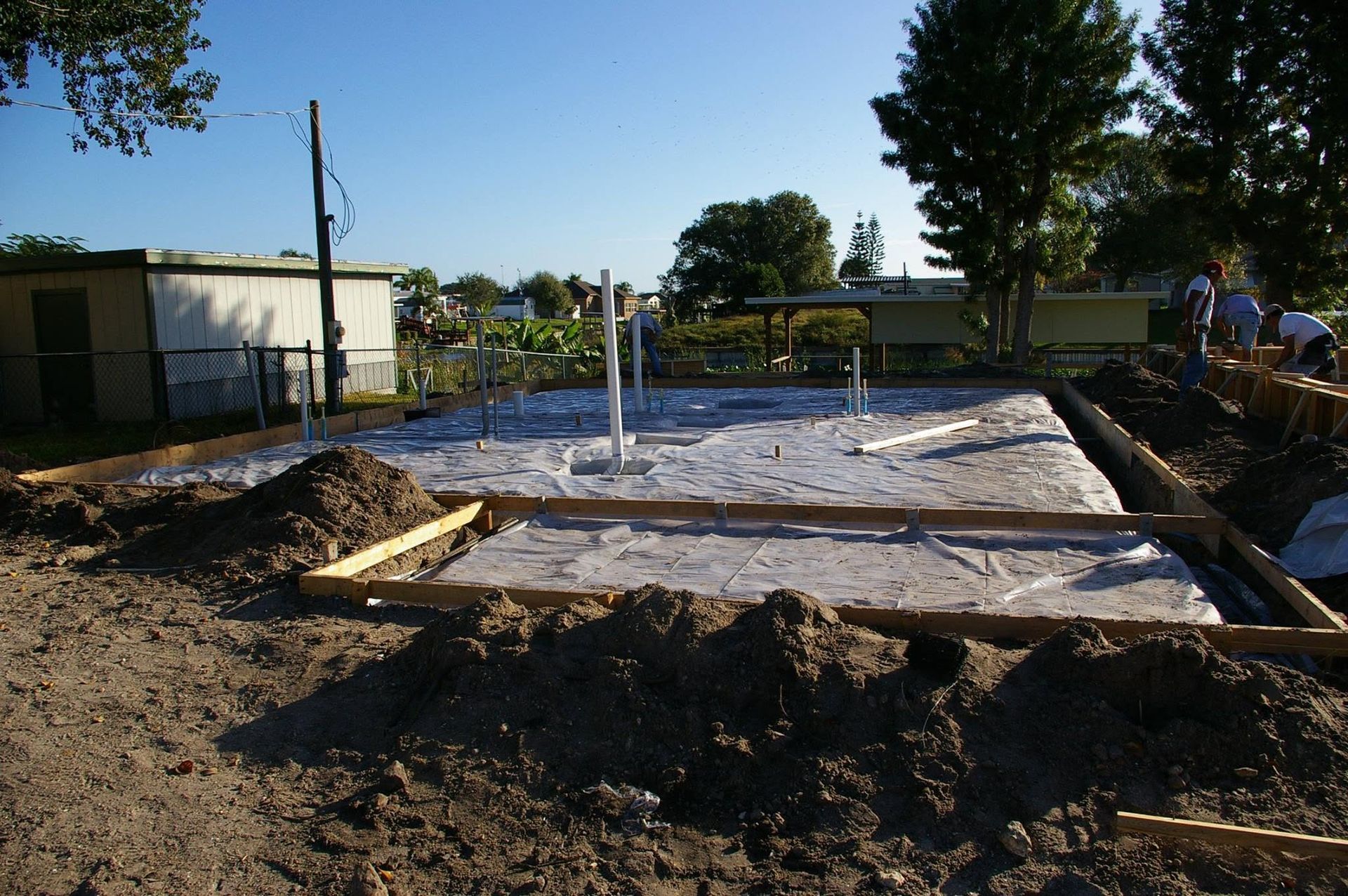 Concrete slab being poured for a building foundation at an outdoor construction site.