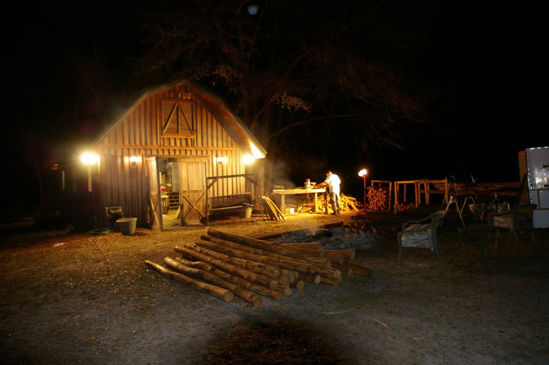 Lit rustic cabin at night with warm porch lights and steps leading to the entrance