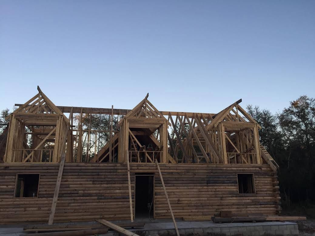 Partially built wooden house frame under construction at dusk