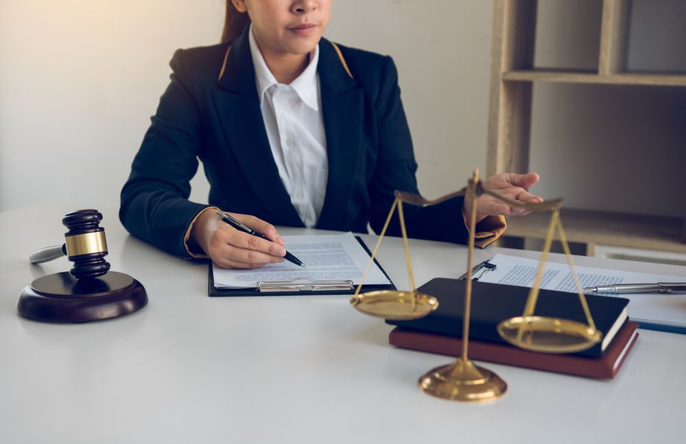 Lawyer in a Suit Seated at a Desk, Scales of Justice — Umbrella Legal in Gosford, NSW