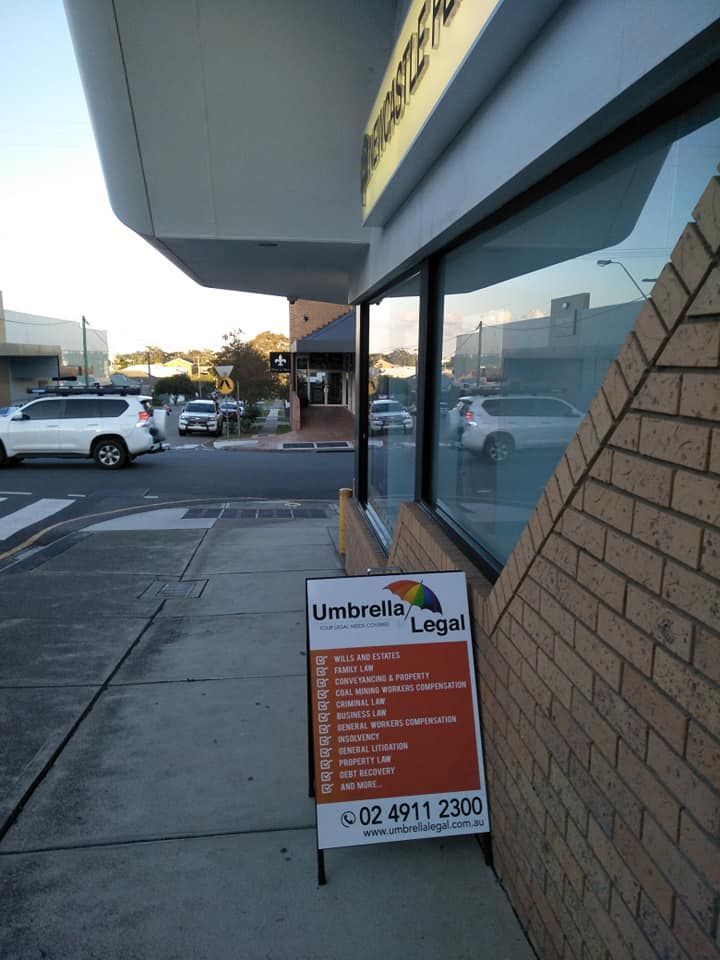 Sign for Umbrella Legal, Showing Services, on Sidewalk — Umbrella Legal in Cessnock, NSW