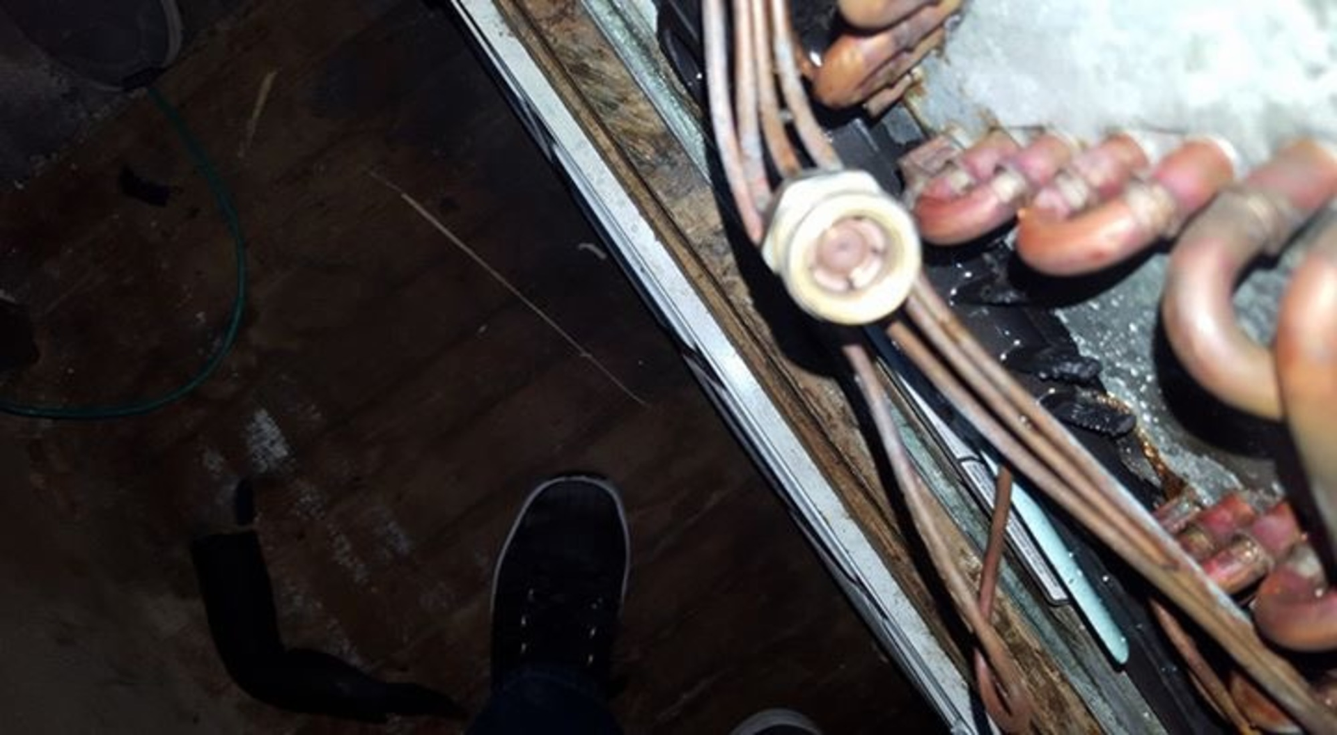 A person is standing next to a bunch of wires and pipes