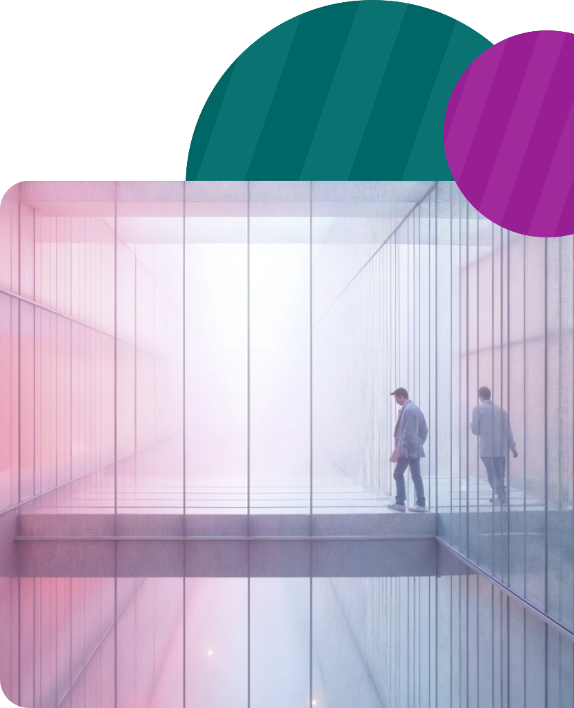A person walks along a glass-walled corridor filled with a soft, pink-tinted haze, creating a reflective, surreal atmosphere.