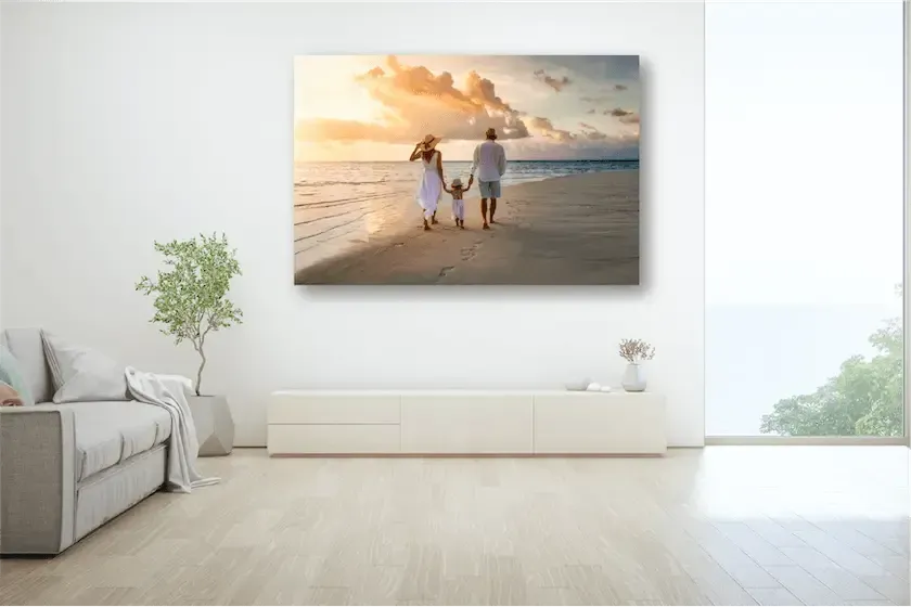 Canvas print on a wall with two people walking on the beach at sunset