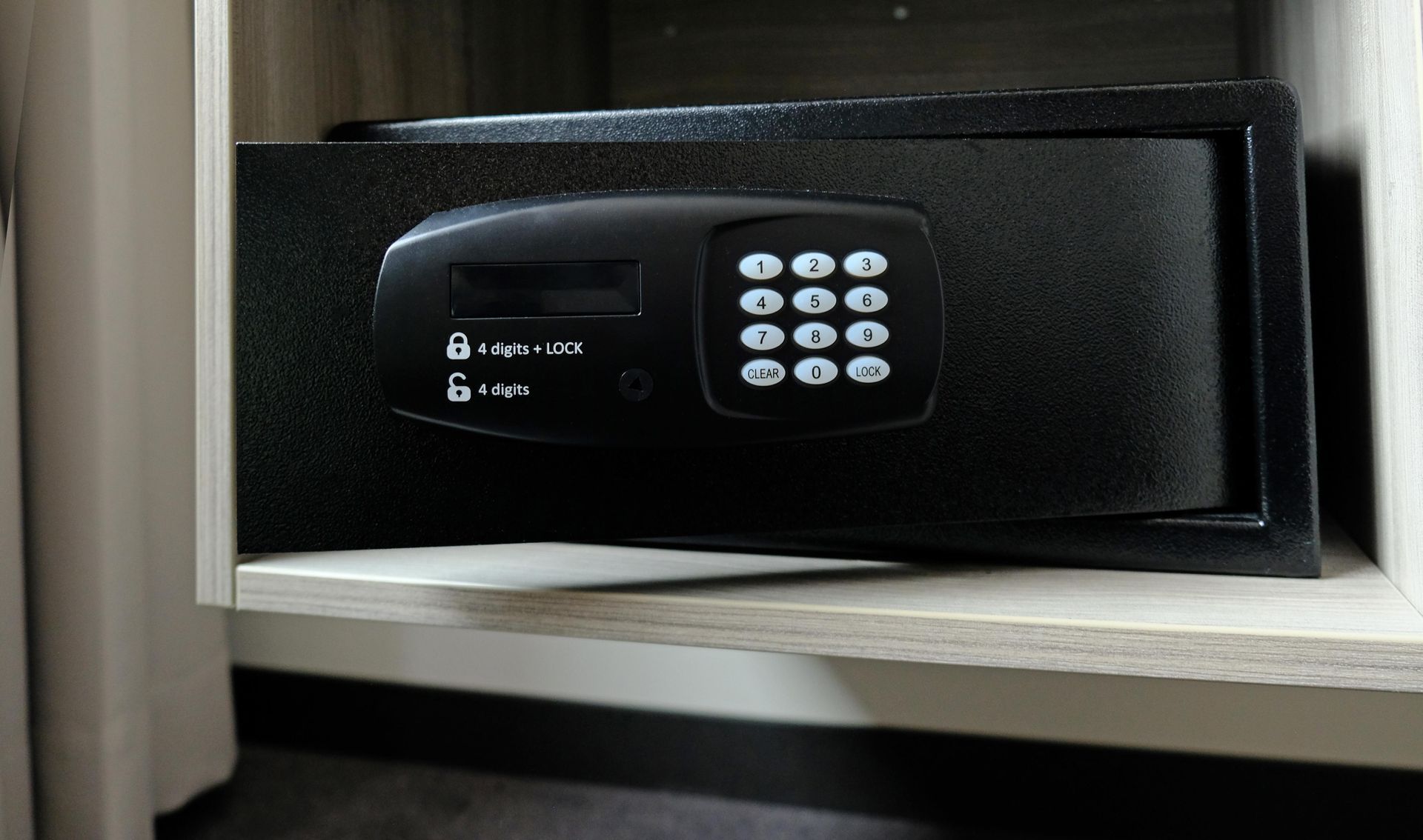 Una caja fuerte digital se encuentra en un estante en una habitación.