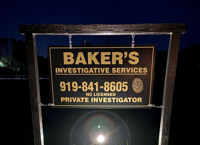 A sign for baker 's investigative services is lit up at night