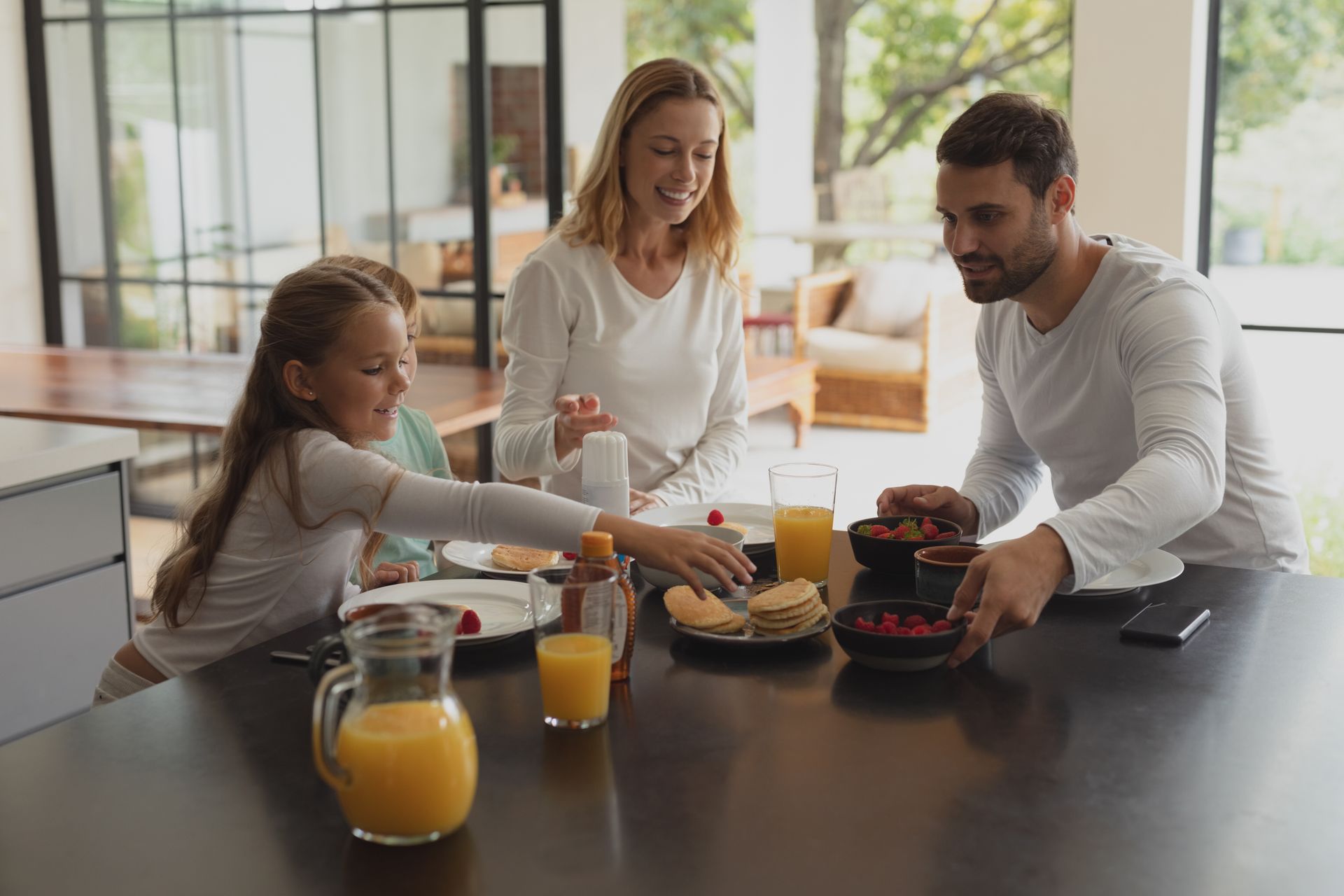 Family eating breakfast together at a kitchen table.