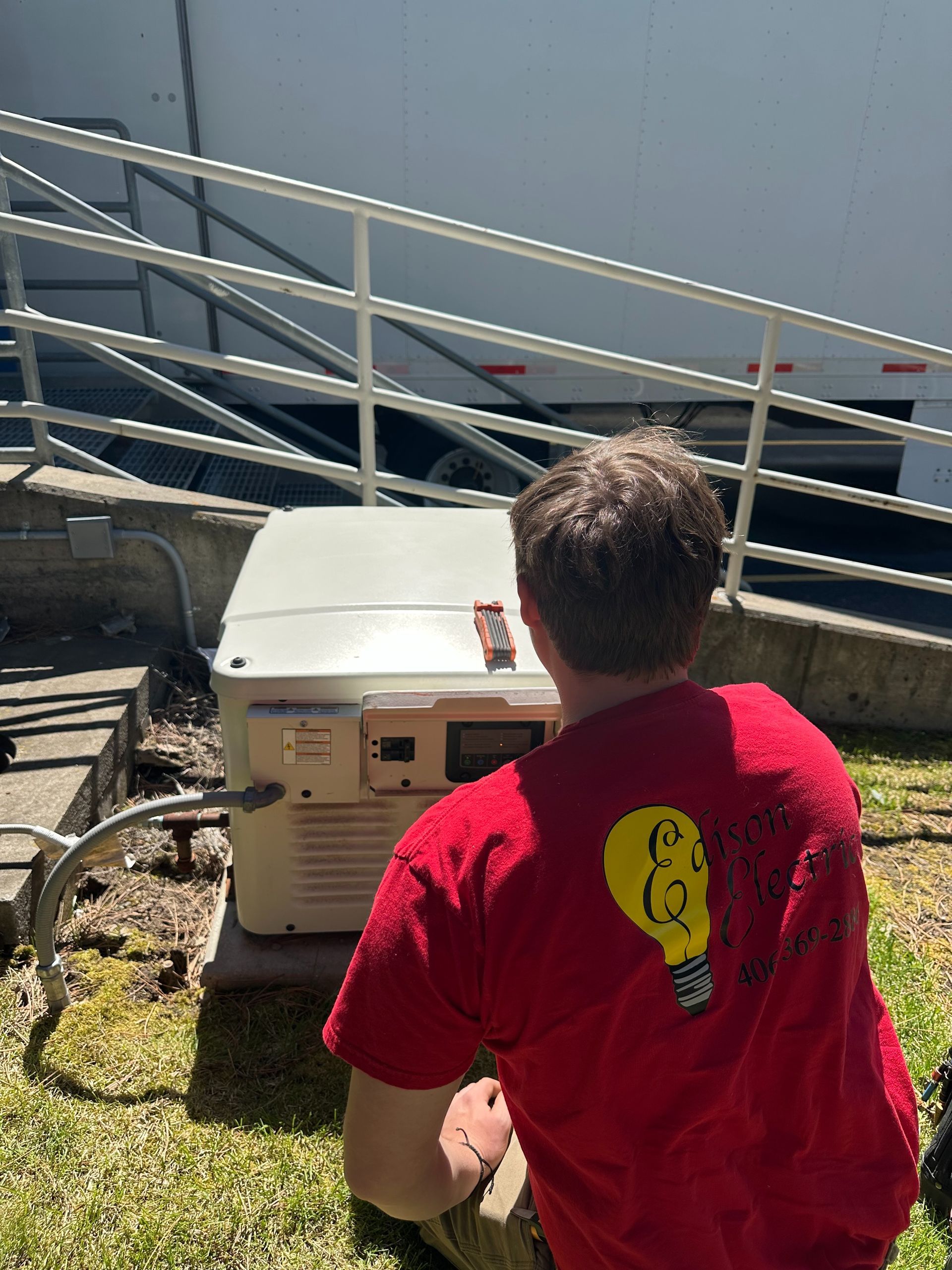A technician in a high-visibility jacket installs or services a gray solar inverter mounted on a wall.