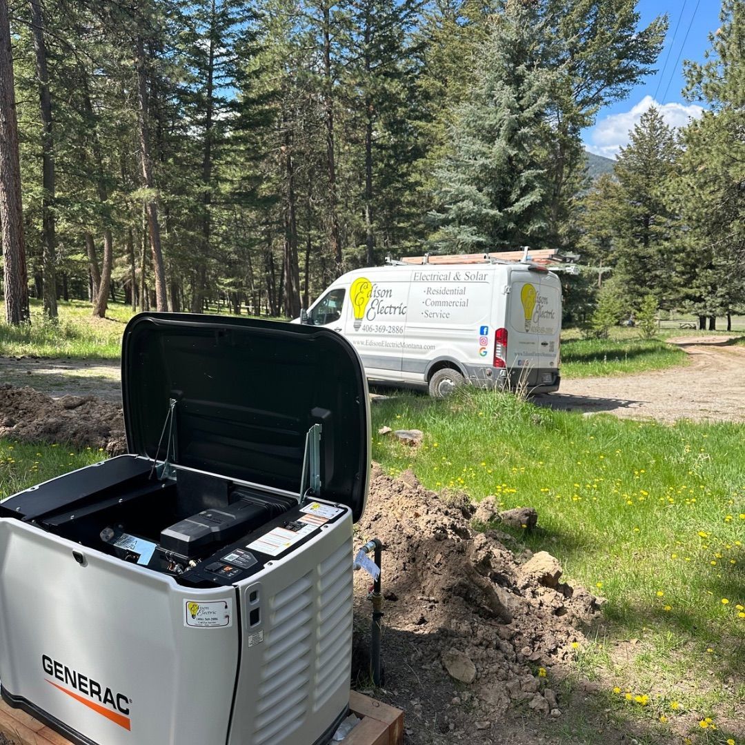 Generator in foreground with open lid; white utility van parked on a dirt path in a pine forest.