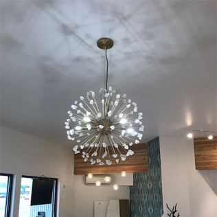 Modern interior with a large spherical pendant light and wood-paneled accents on the ceiling.