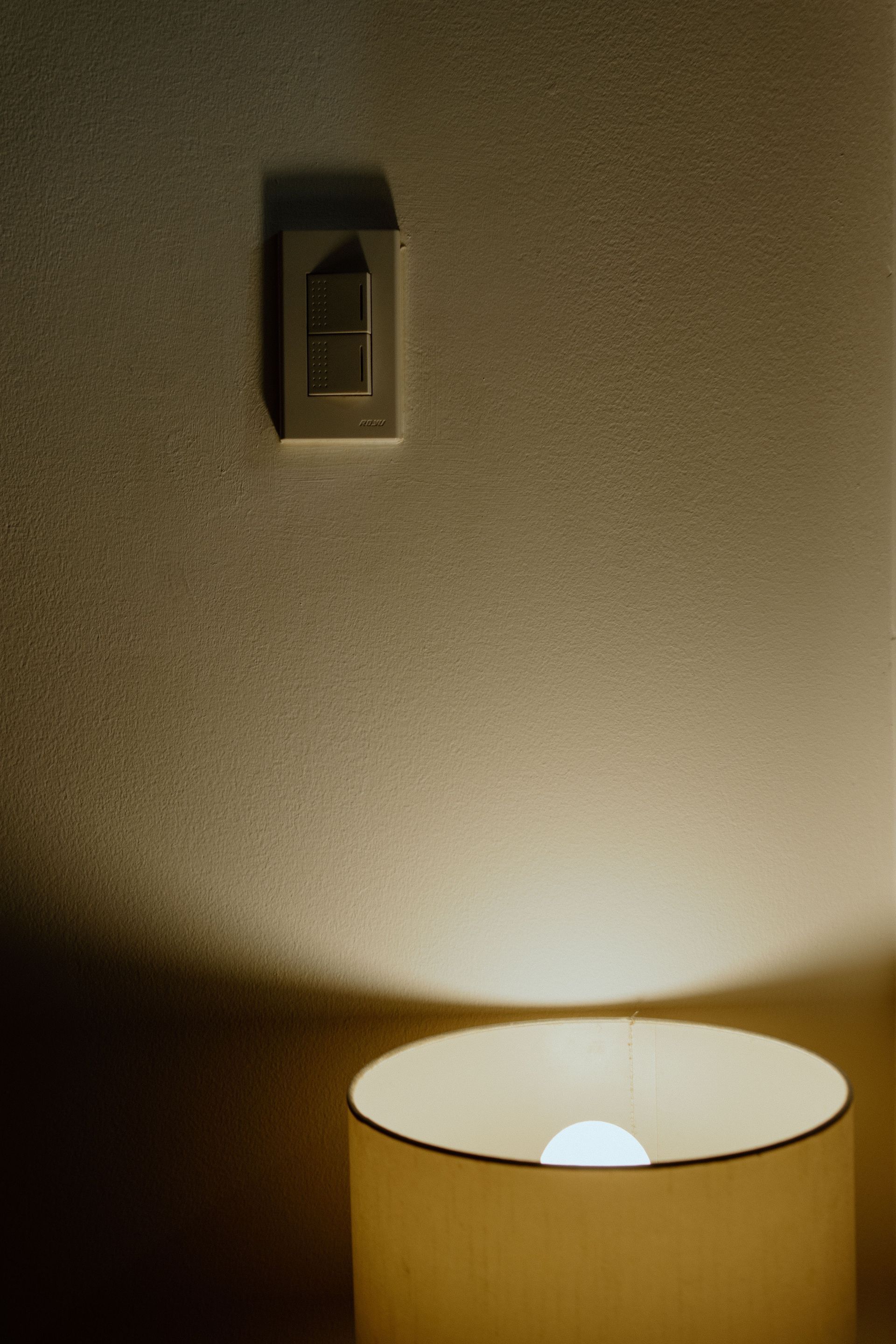 White ceiling ventilation grille with a dark circular fan or vent in the center