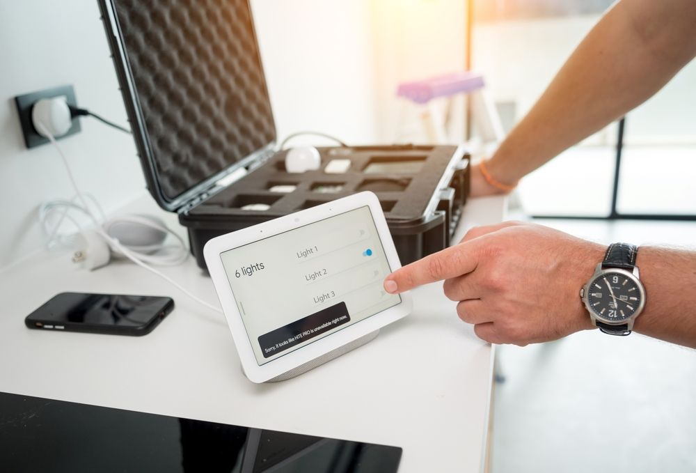 Person adjusting a tablet next to an open suitcase on a desk