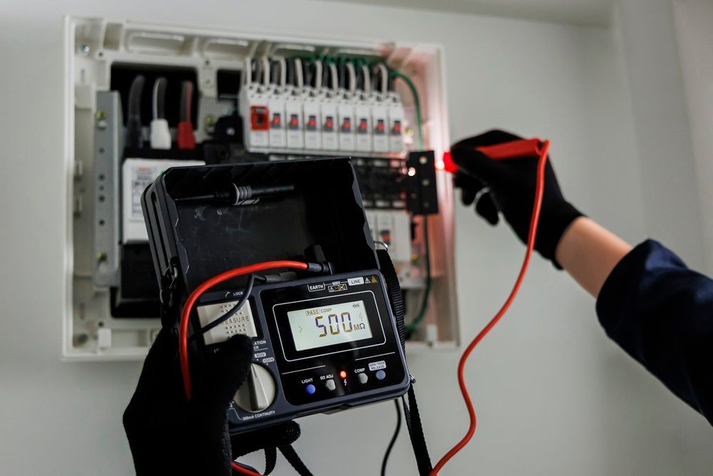 Electrician testing a circuit breaker panel with a multimeter and red probe wire.