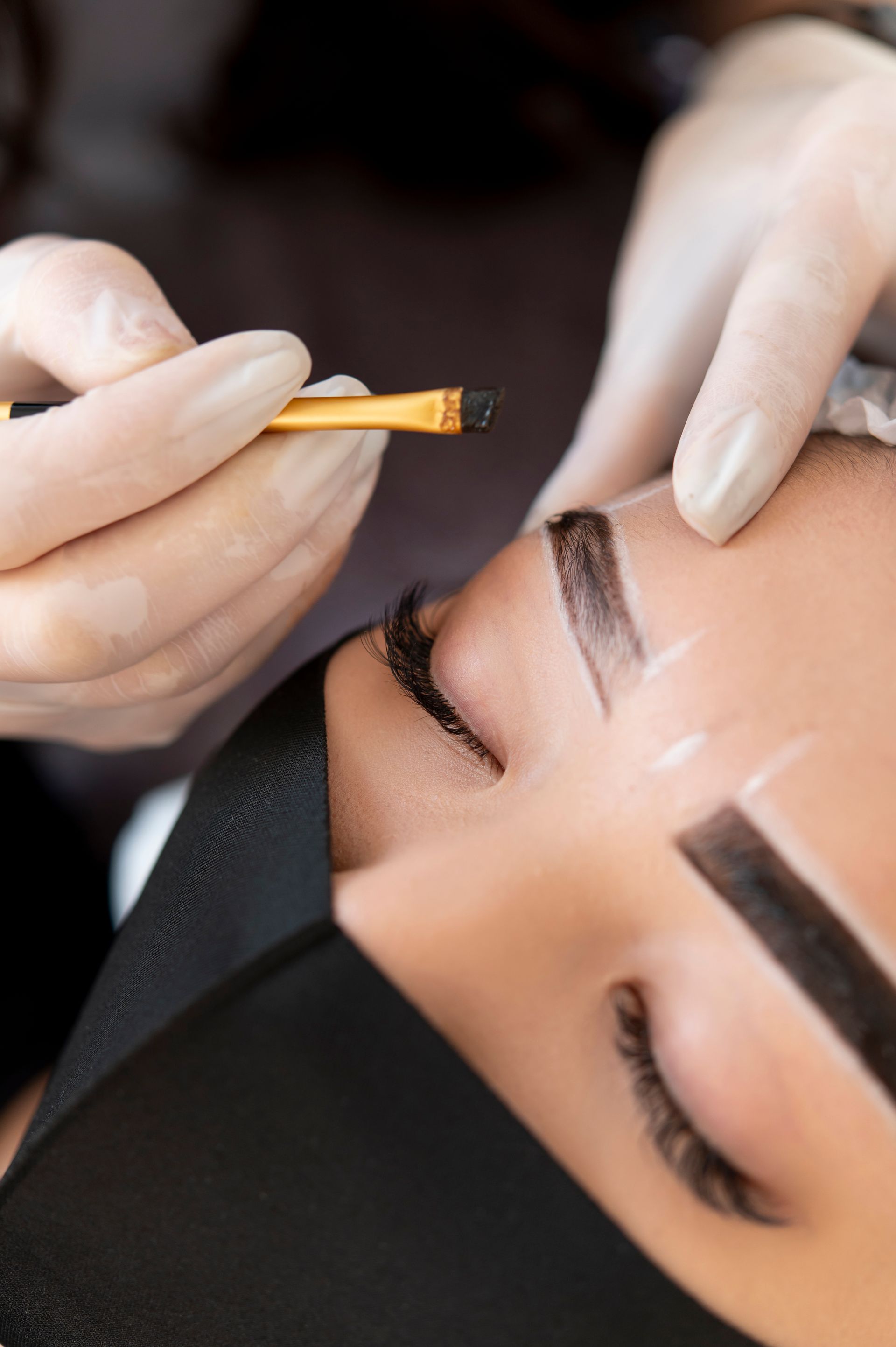 a woman is getting her eyebrows painted in a salon .