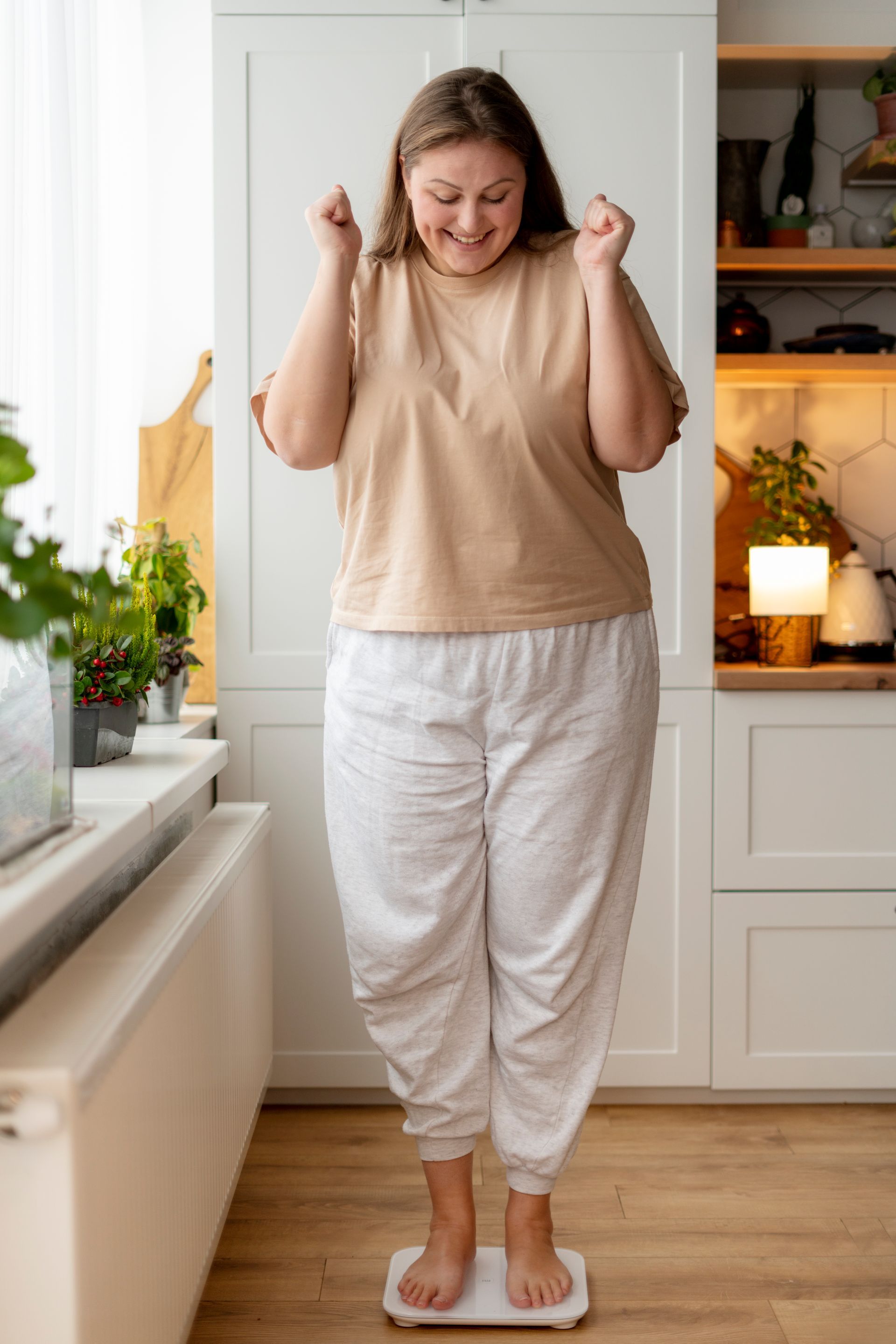 a woman is standing on a scale in a kitchen .