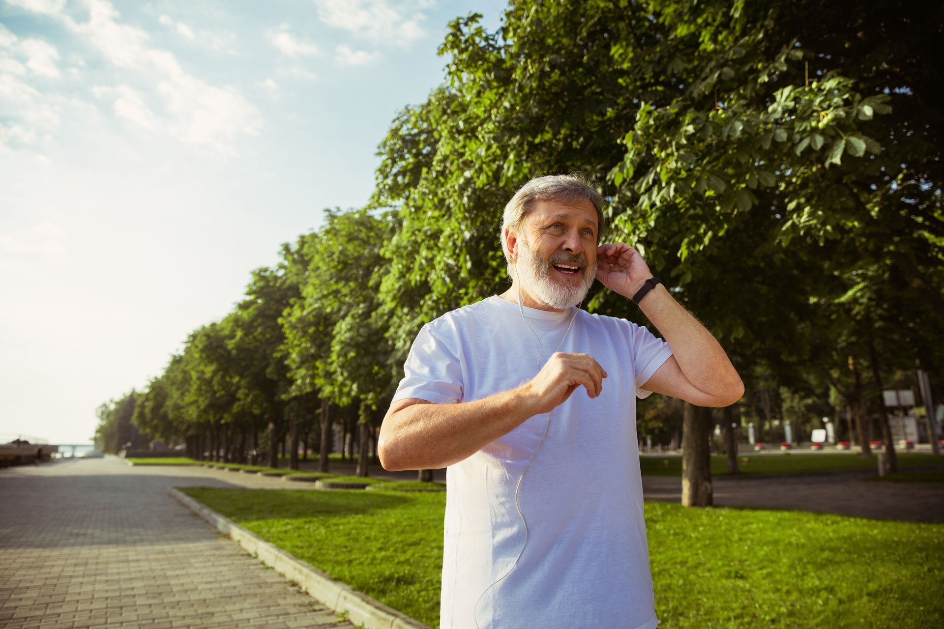 an older man is talking on a cell phone in a park .