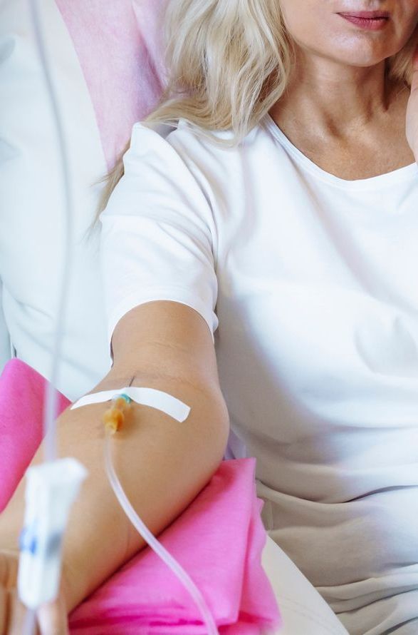 a woman is sitting in a hospital bed getting an injection .