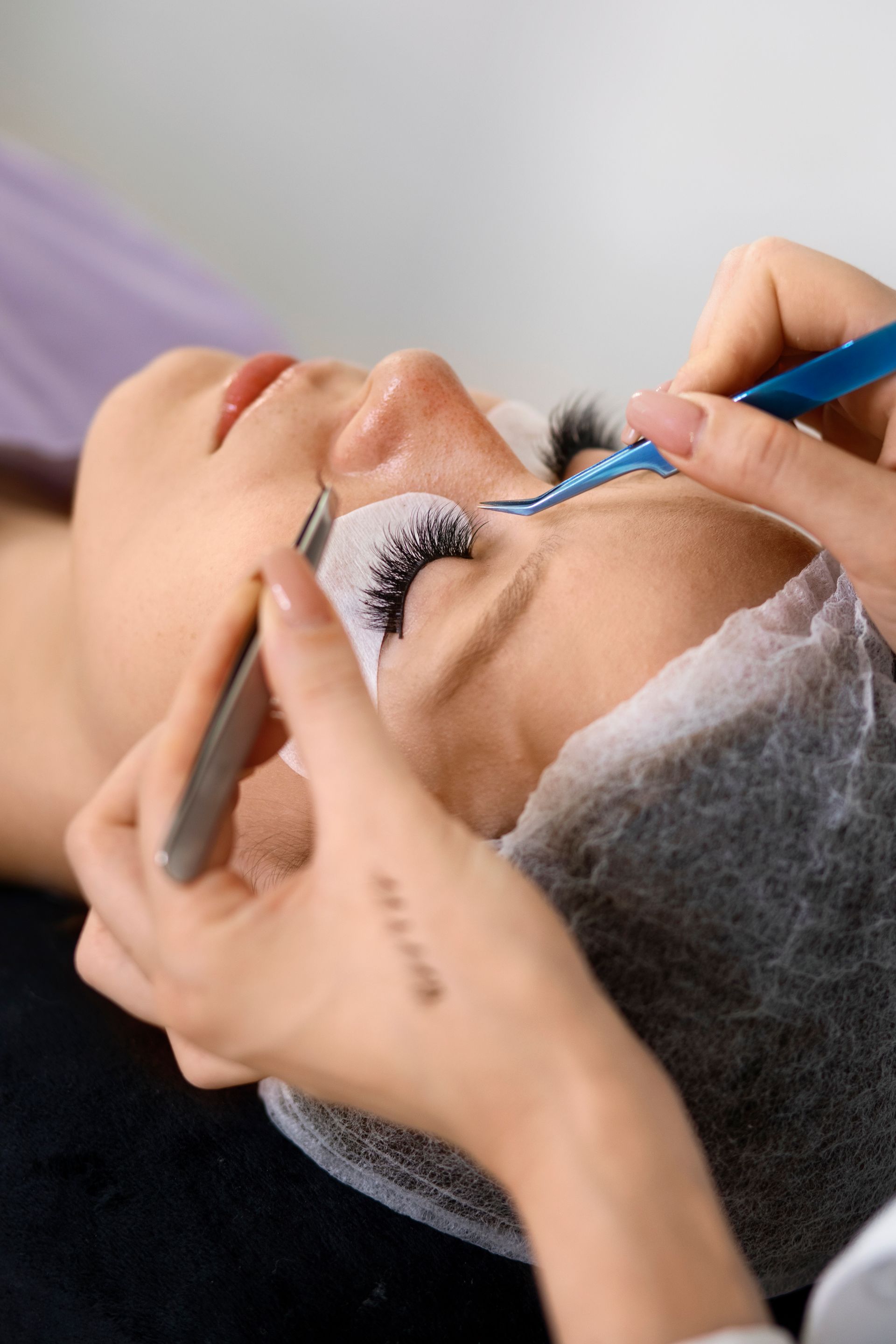 a woman is getting her eyelashes done at a beauty salon .