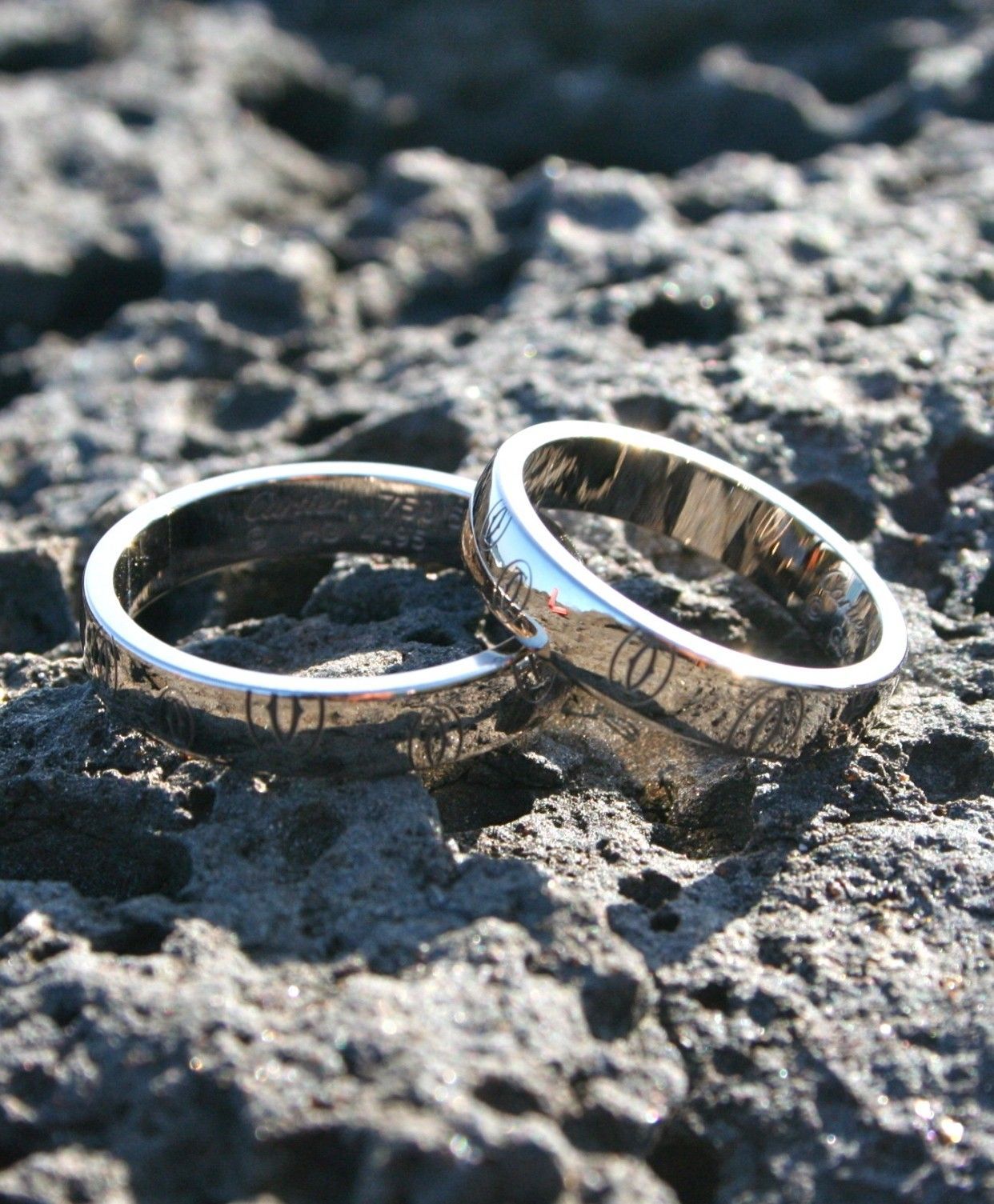 Two silver rings on a rocky surface