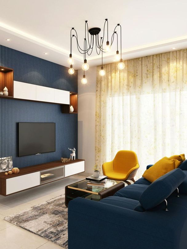 Modern living room with a blue sofa, yellow chair, and a decorative chandelier.