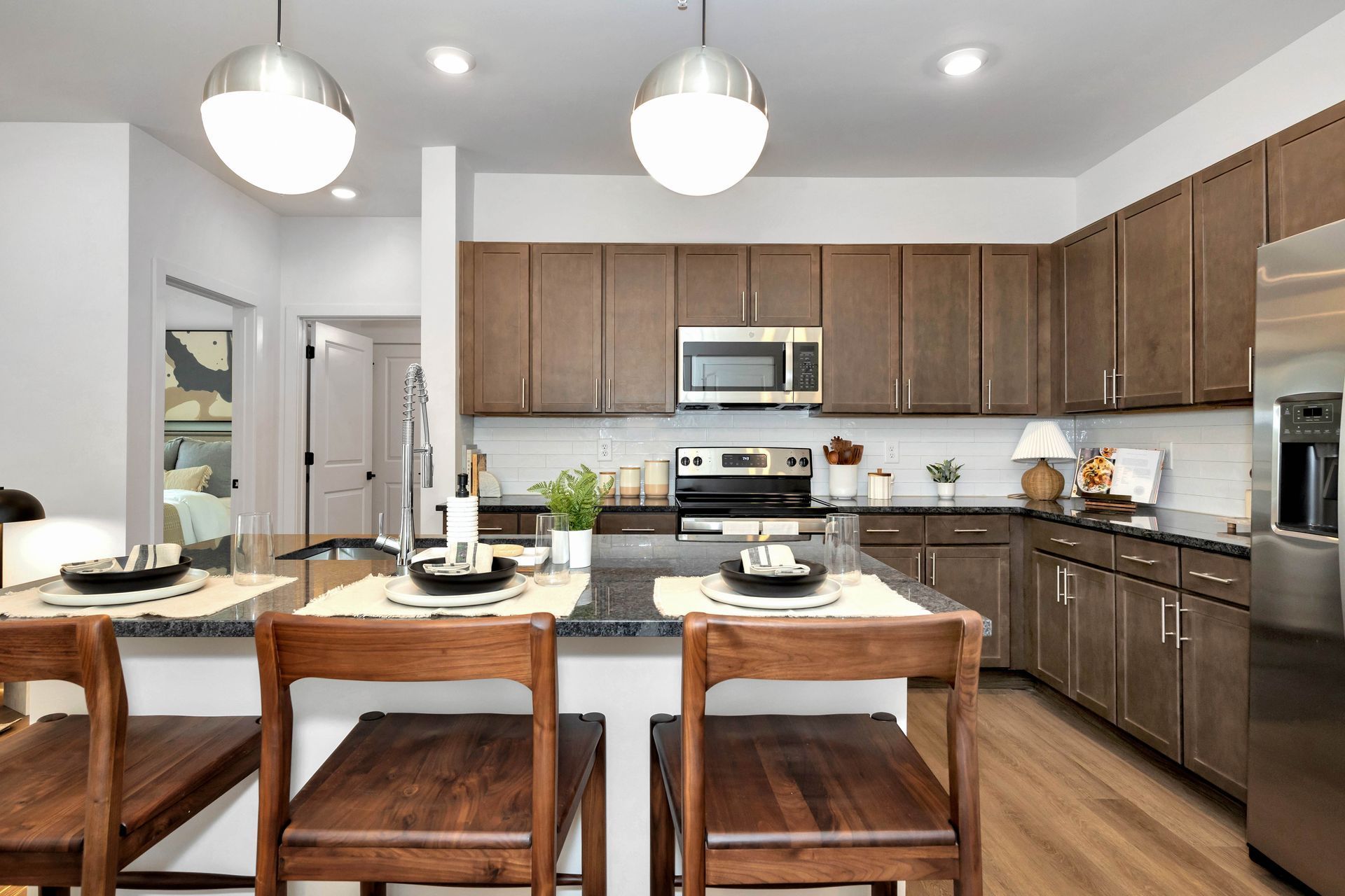 Modern kitchen with cherry wood cabinetry at Livano at Town Madison.
