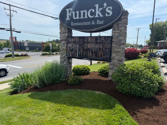 Funck’s Restaurant & Bar sign by a roadside with landscaping and a parking lot behind it