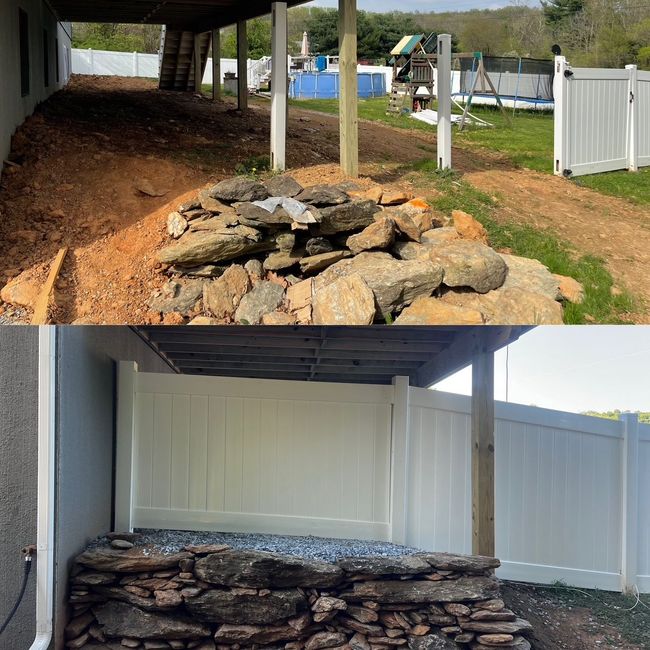 Side-by-side view of a rock retaining wall before and after, under a covered patio beside a white fence.