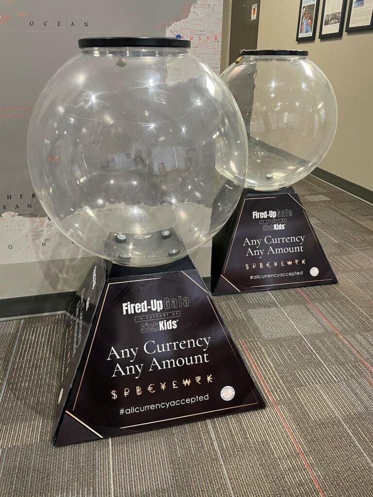 Two gumball machines are sitting on a carpet in a room.