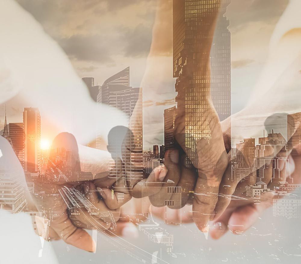 A group of people are holding hands in front of a city skyline.