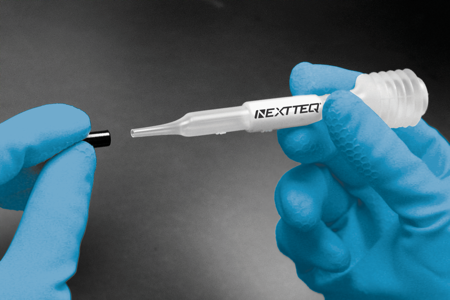 Two hands demonstrating how to use the Nextteq® VeriFit® Irritant Smoke Generator. Step 2. Remove the black cap.