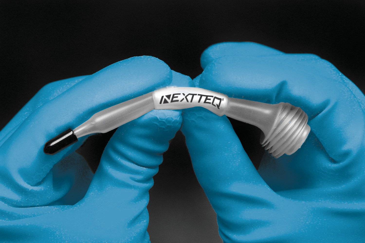 Two hands demonstrating how to use the Nextteq® VeriFit® Irritant Smoke Generator. Step 1. Break the ampoule.