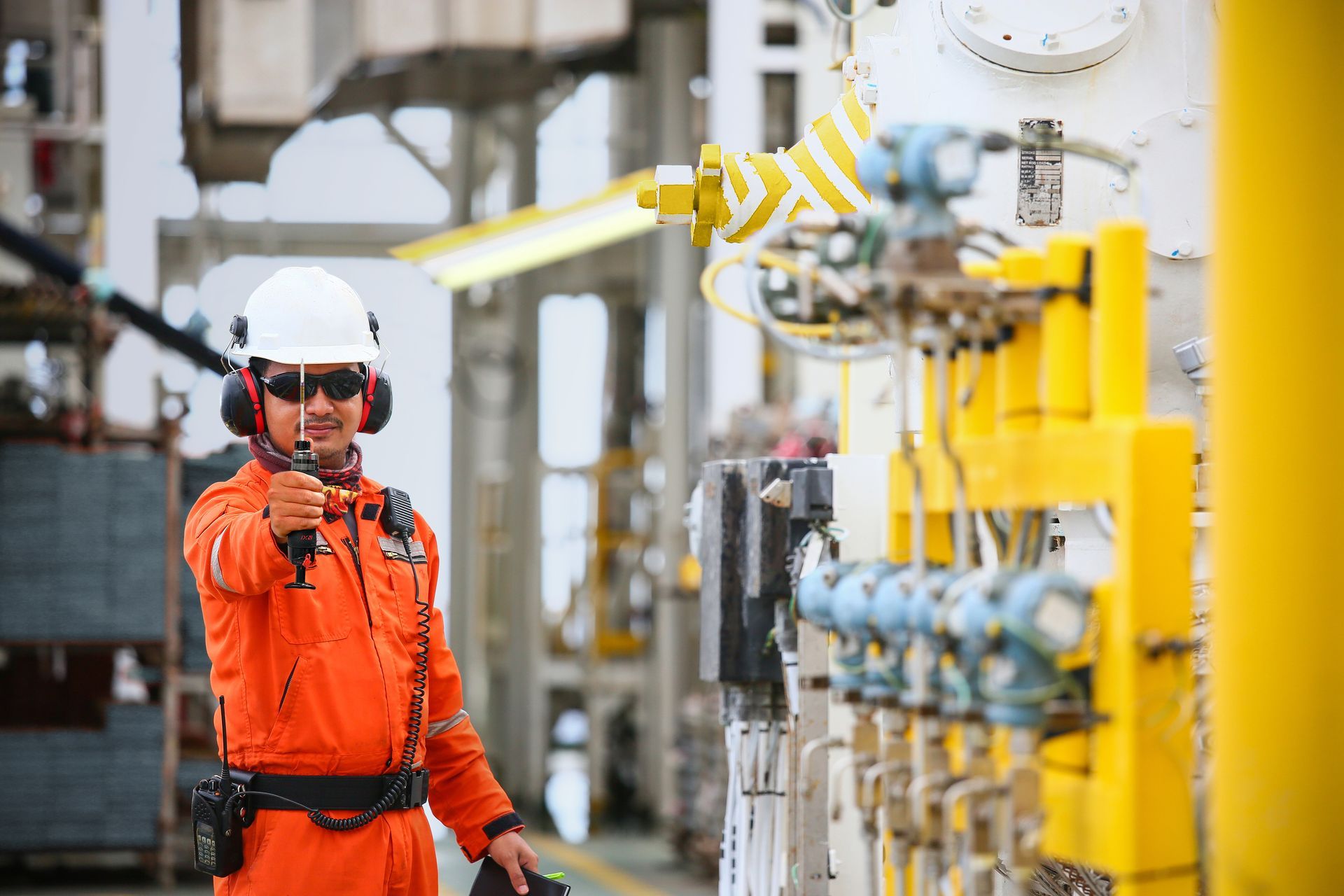 A man in an industrial setting proudly holding a Nextteq® NX-1000 Sampling Pump.