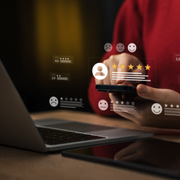 Laptop and smartphone with floating customer rating icons and star reviews on a desk