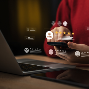 Laptop and smartphone with floating customer rating icons and star reviews on a desk