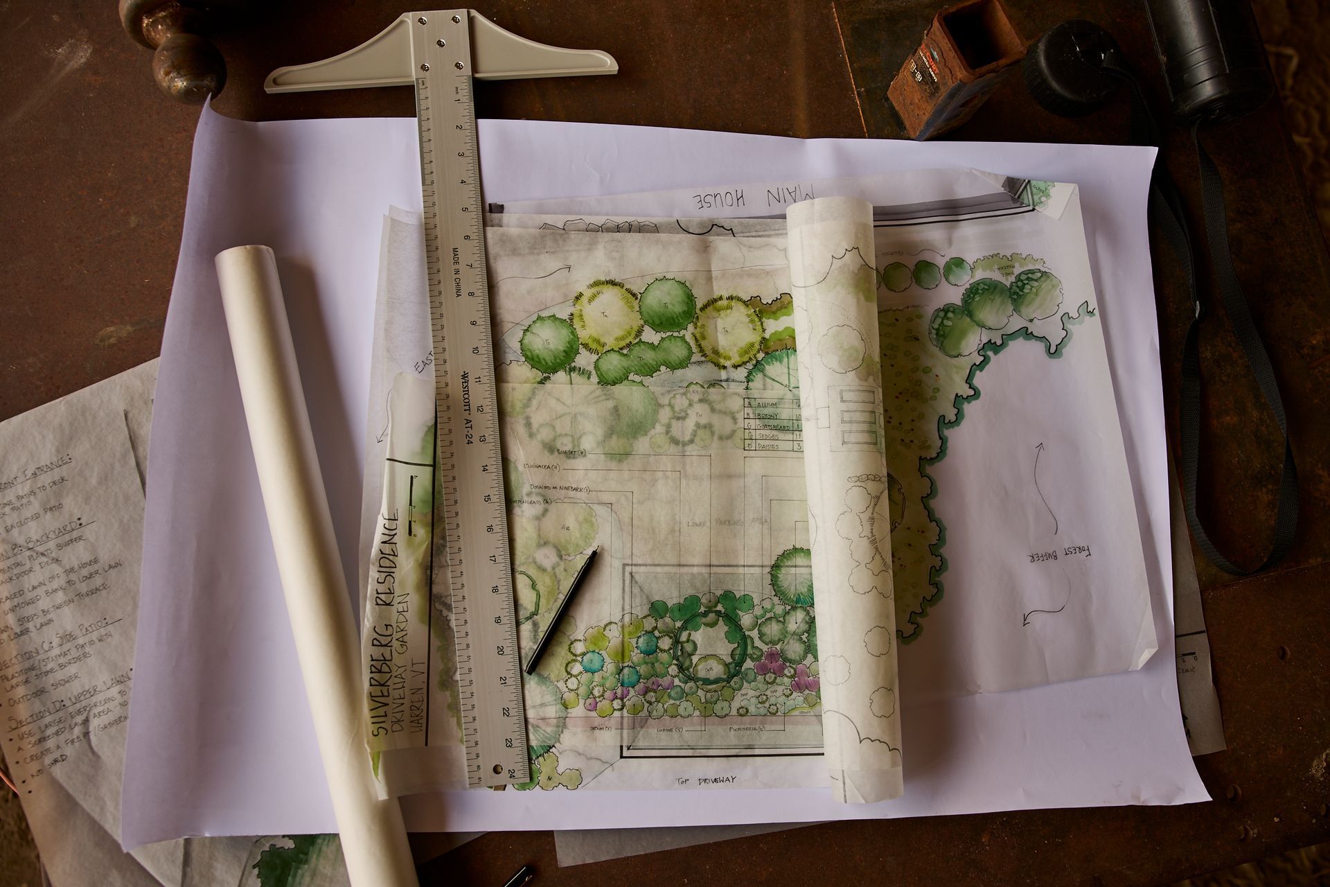Draft landscape sketch on paper with rulers and pencils laid over it on a wooden desk