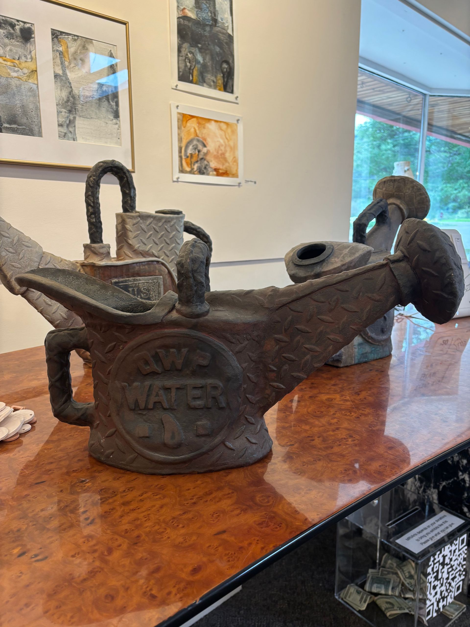 Antique black cast-iron coffee mill on a polished wooden table in a bright room.