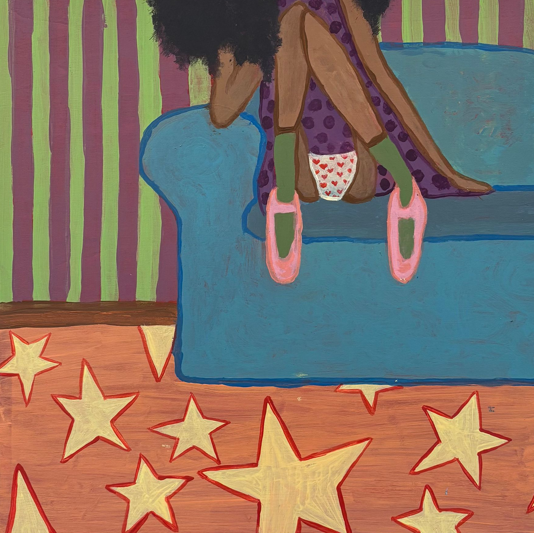 Child on a blue couch wearing pink shoes; striped wall and star-patterned rug in the background