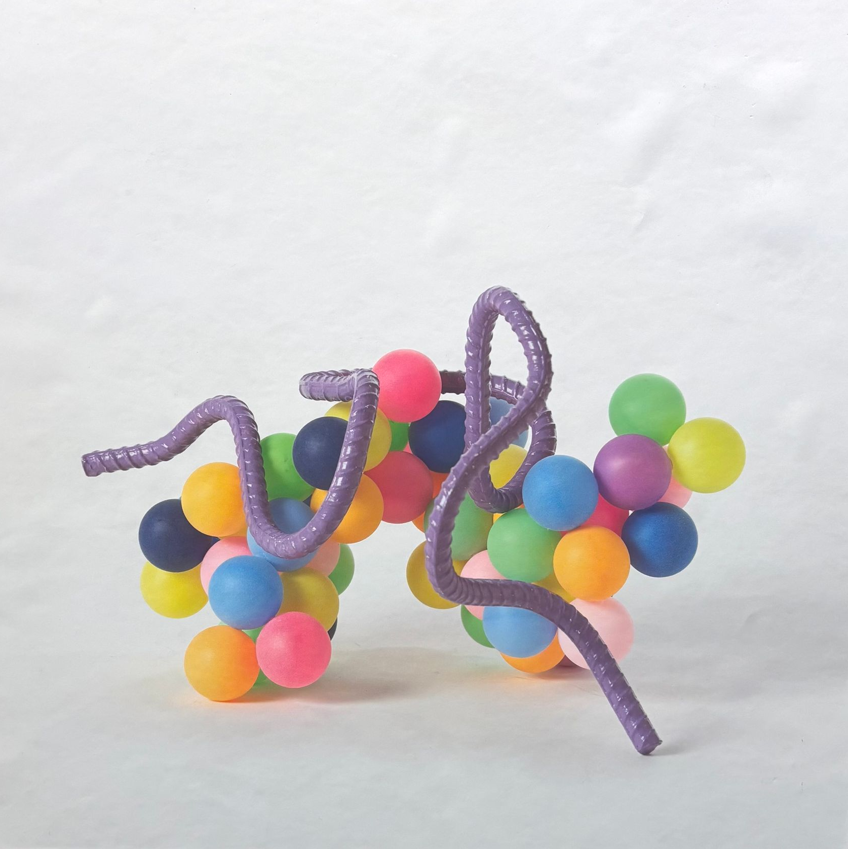 Colorful bead-and-pipe-cleaner caterpillar sculpture on a white background