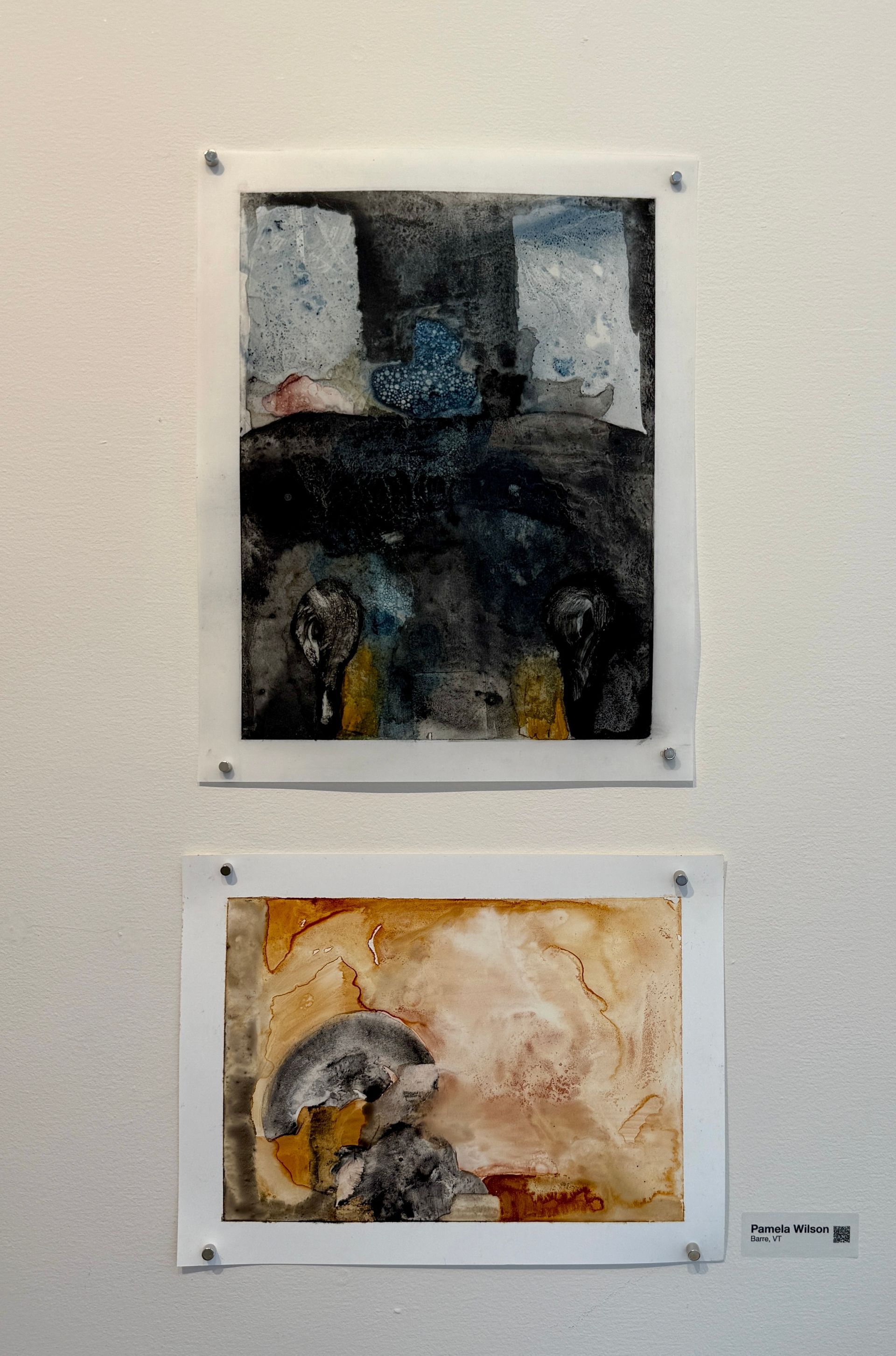 Two abstract paintings mounted on a white wall, one dark and one in warm beige tones.