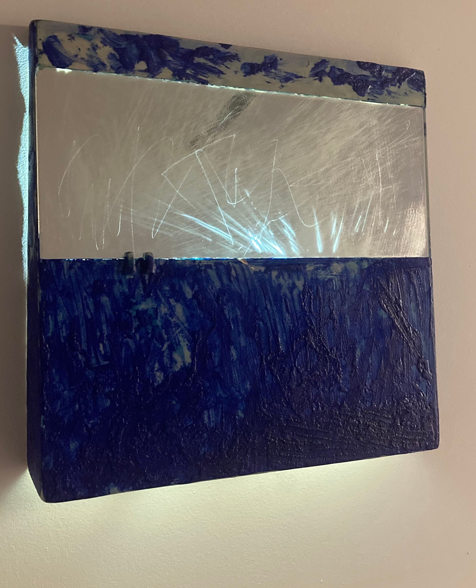 Blue and white folded paper or cardboard on a beige surface, wrapped in clear plastic.