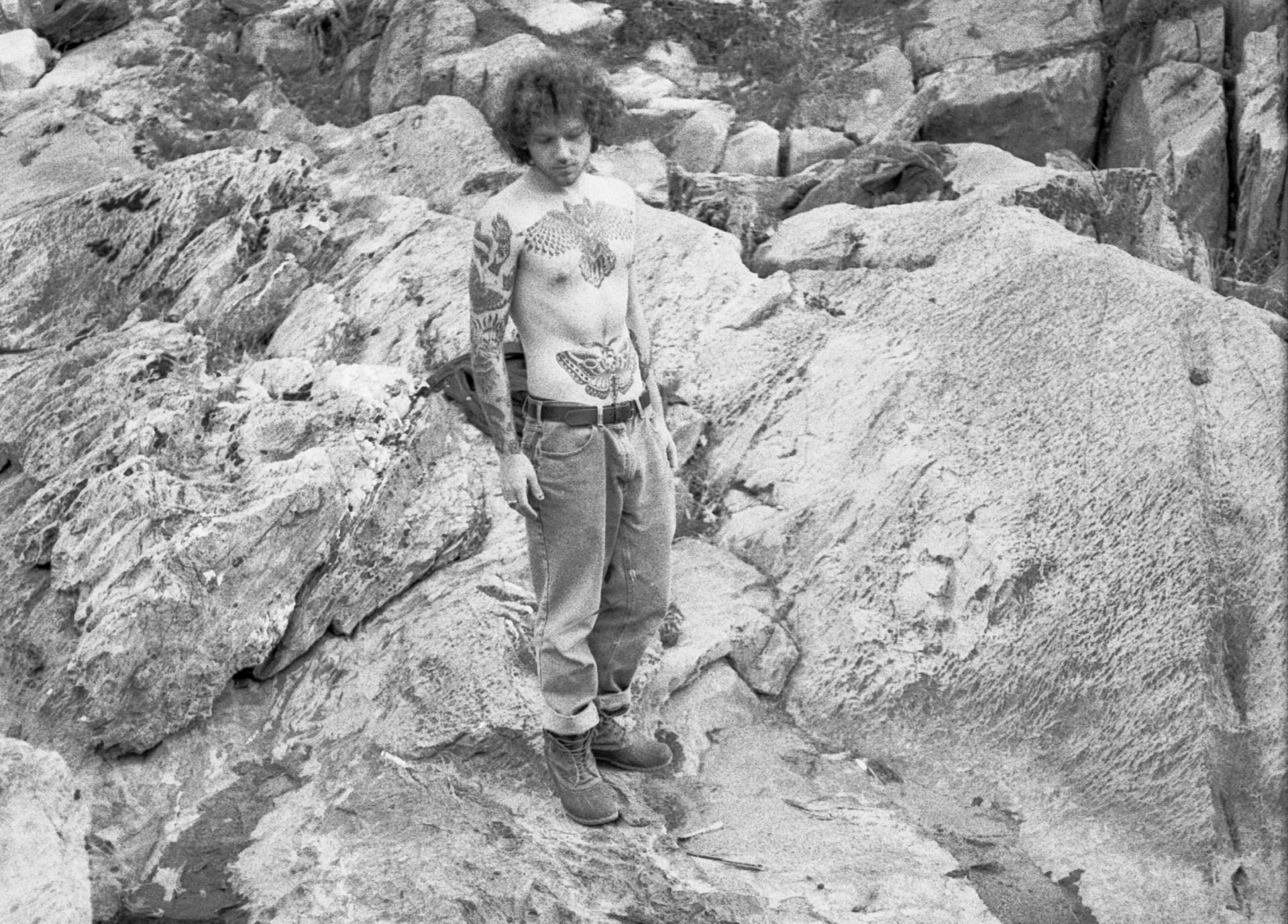 Person standing on rocky terrain in a black-and-white outdoor scene