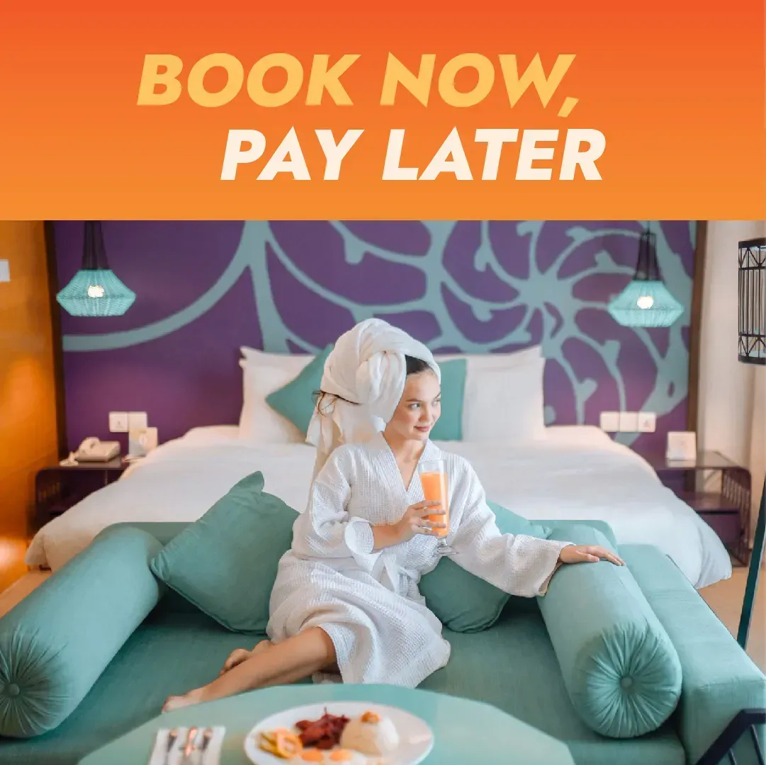 Child in a white bathrobe sits on a bed with a breakfast tray under “Book Now Pay Later” text.